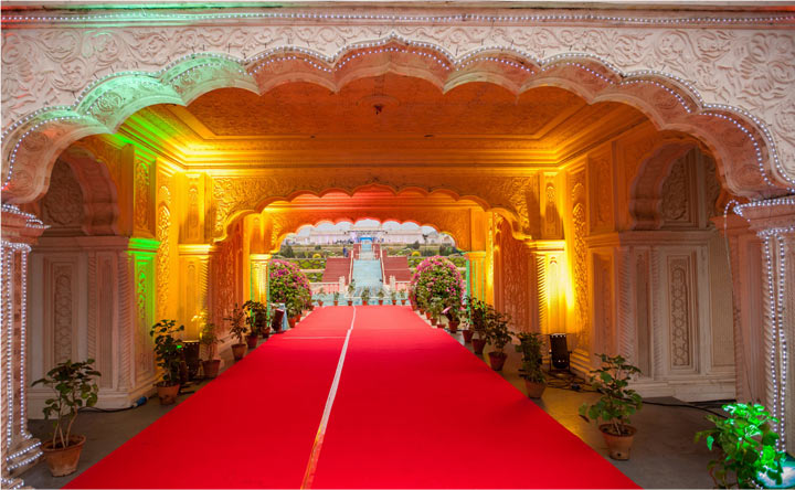 Royal look wedding theme in Hyderabad at Ramoji Film City featuring ornate archways, red carpet, traditional architecture, and a regal garden pathway.